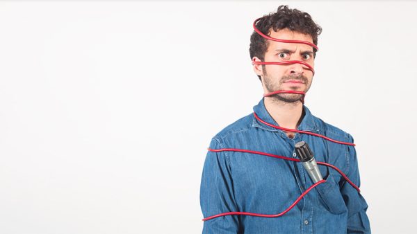 Edoardo Ferrario legato dal filo rosso del suo microfono e microfono messo nella tasca della camicia jeans